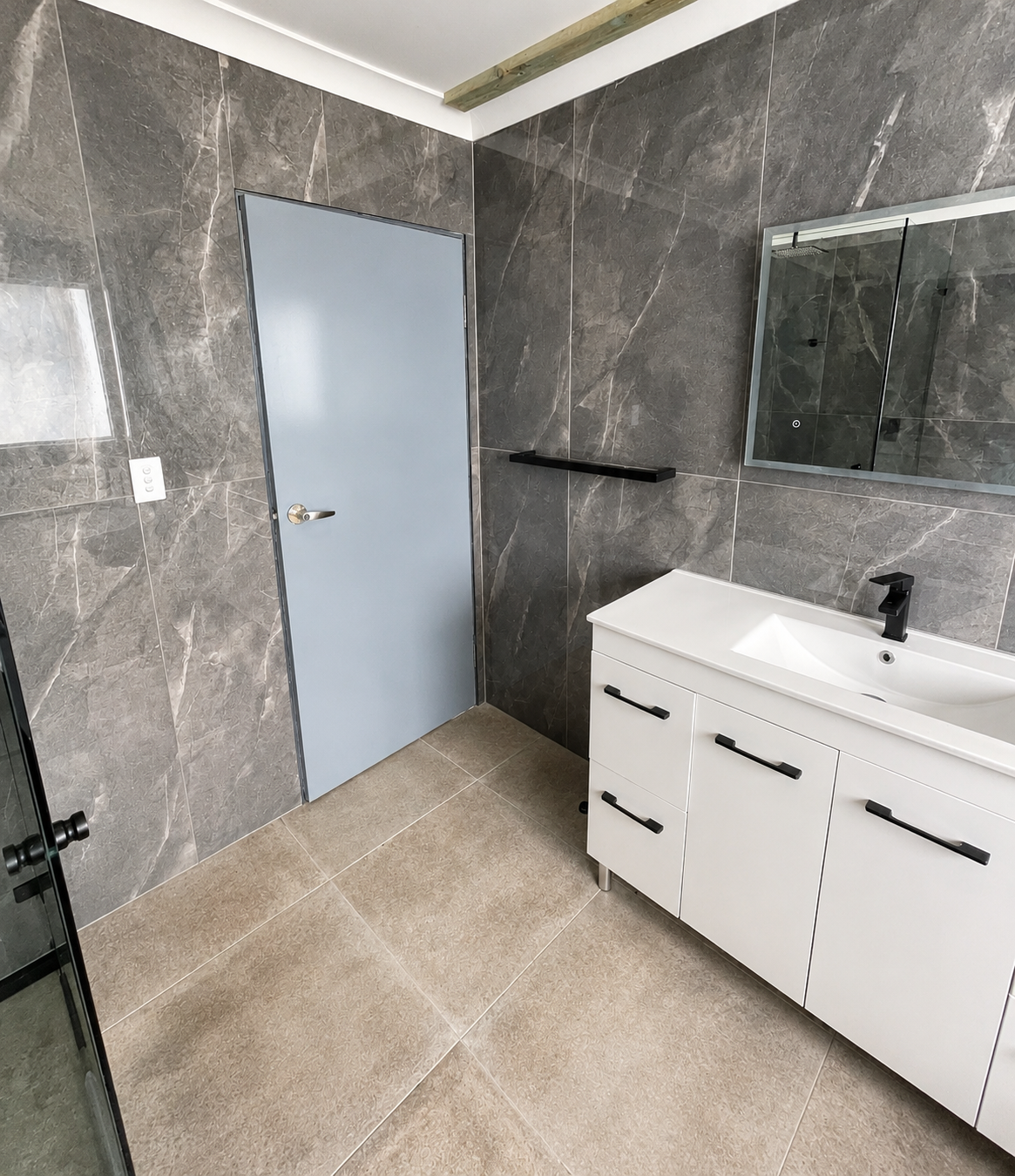 Completed main bathroom entrance with wall-hung vanity and mirror