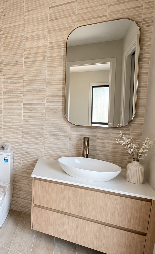 Completed neutral floating vanity with gold fixtures and wall-hung mirror