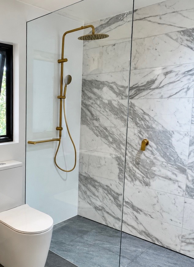 Completed ensuite waterfall shower with gold fixtures