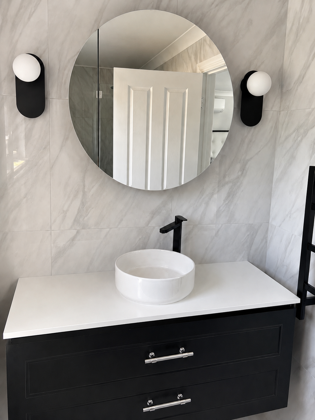 Completed marble bathroom with black vanity