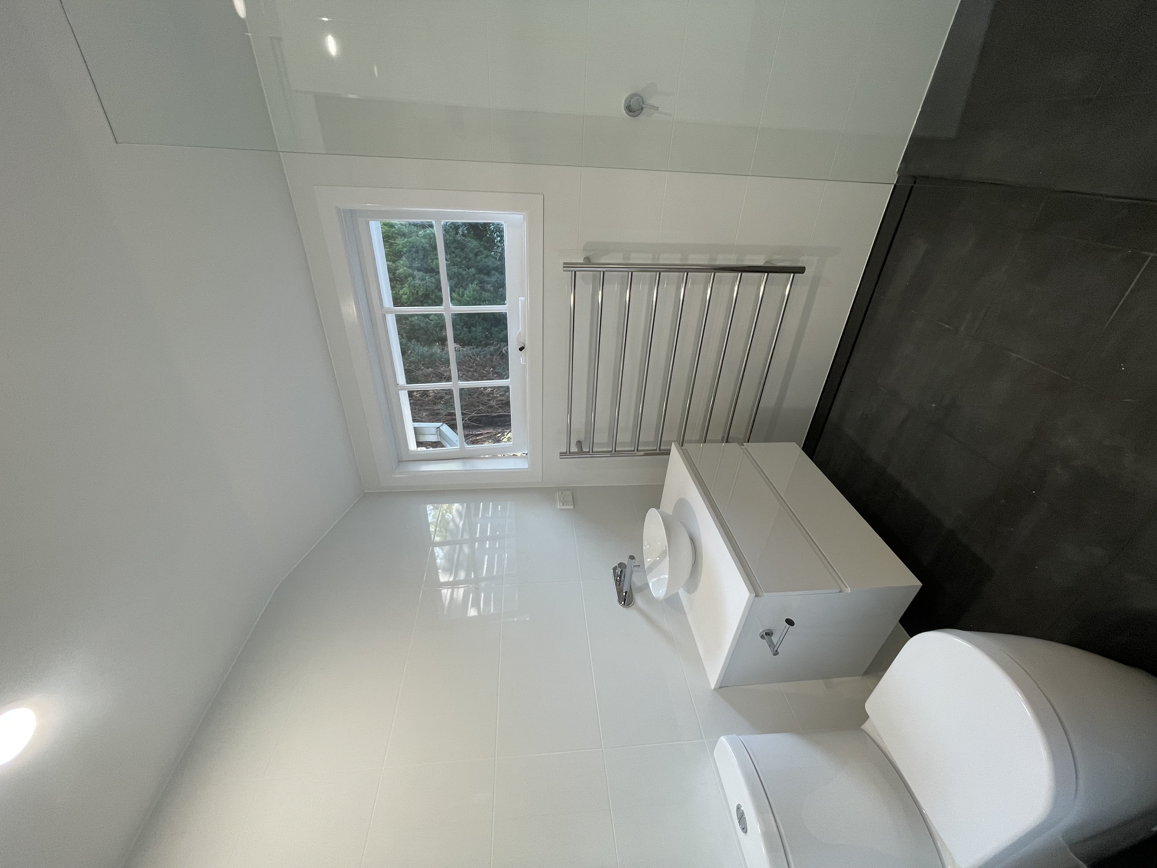 Completed small white ensuite with toilet and vanity