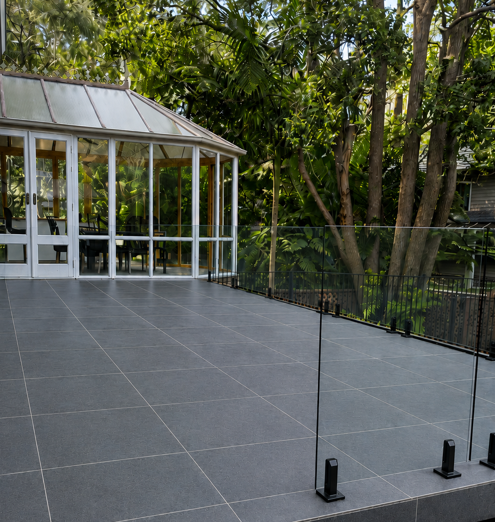 Completed exterior patio floor tiling with glass fence