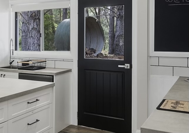 Completed traditional farmhouse kitchen with black feature door and subway tiles